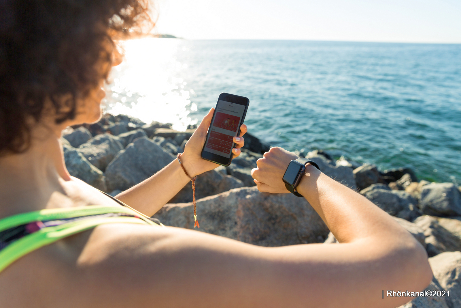 Young fitness woman setting up her smartwatch for the run outdoors